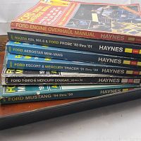 Stack of seven Haynes repair manuals for Ford and Mazda vehicles showing titles on the spines