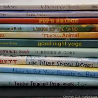 Stack of 11 hardcover children's books showing spines with titles and authors.