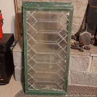 Photo of one vintage leaded glass window with green painted wooden frame, showing the full window and its diamond leaded glass design.
