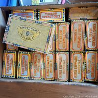A full open box filled with 17 empty vintage King Edward cigar boxes showing two distinct label designs: King Edward Imperial and King Edward Mild Tobaccos, all used with visible signs of age and storage marks.
