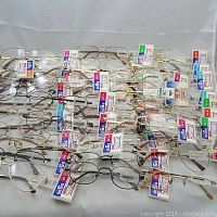 Full lot of 41 pairs of reading glasses arranged in rows showing various frame styles and strength tags.