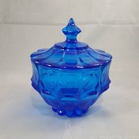 Front view of Fenton Valencia Colonial Blue covered candy dish showing its detailed faceted pattern and pointed lid finial.
