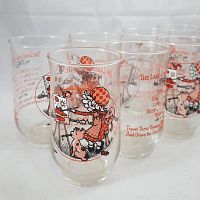 Lot of eight clear drinking glasses featuring kitschy Daisy character art and red text.