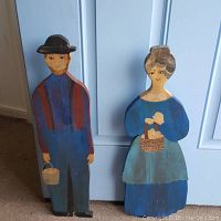 Full view of the handpainted wooden folk art couple, man and woman standing side by side against a light background