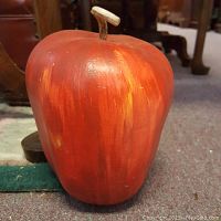 Front and top view of the handpainted gourd birdhouse shaped like an apple showing the apple's rounded form and wooden stem on top.