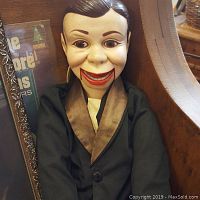 Front view of the Charley McCarthy doll seated, showing its facial features, clothing, and intact overall appearance.