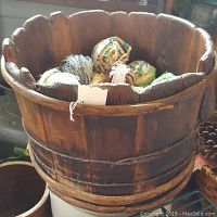 Front view showing the full handmade wooden bucket filled with colorful rag balls.