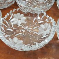 Close-up of one cut lead crystal dish showing detailed floral and starburst cut patterns and scalloped edge.