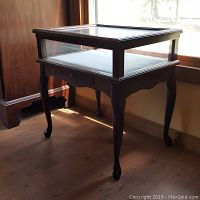Vintage Bombay Co curio table with Queen Anne legs and single drawer, viewed from side near window with natural light showing shape and details.