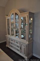 Full front view of assembled two-piece china cabinet showing glass doors, drawers and finish