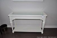 Full front view of the white hall or sofa table showing glass top and lower shelf