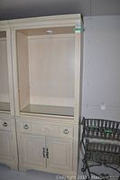 Full view of the Stanley shelf unit showing open upper section, drawer and cabinet doors below, cream color with fluted column detail.