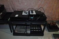 Photo showing stacked Sony players on a plastic stand in basement setting.