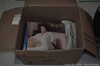 Photo of cardboard box containing multiple vinyl record albums with Neil Diamond album on top.