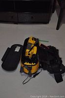 Photo of the yellow Sony Handycam Sports underwater video camera with attached cables and its yellow carrying case, also showing a black JVC camera case.