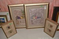 Set of four pictures: two framed prints of sculpted stone vases with birds, two framed shadow boxes with miniature baskets of fruit.