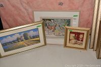 Three framed artworks arranged on a flat surface with a pink backdrop; includes two prints and one original pastel.