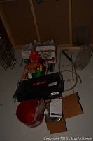 Overall photo of plumbing items including boxed faucet, pail, spray bottles, fluids, and metal rack.