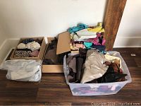 Four containers of mixed leather offcuts including cardboard boxes and plastic bins with assorted colored and textured pieces.