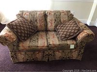 Front view of the love seat showing the patterned fabric upholstery and two cushions.