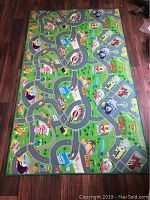 Top view of colorful kids floor mat showing road and town layout