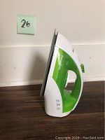 Side view of the Panasonic steam iron showing its green and white plastic body and stainless steel soleplate.