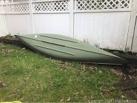 Side view of canoe exterior showing green hull and minor surface scuffs