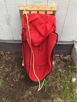 Top-down view showing red padded seat with raised sides and yellow pull rope extending along the sled front.