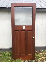 Full front view of the vintage wooden door with glass panel showing its size and details
