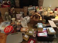 Wide view showing all Christmas decor items including figurines, candles, cards, boxes, nativity scene, and music box in a living room setting.