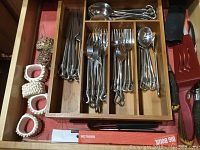 Drawer with metal flatware and white napkin rings
