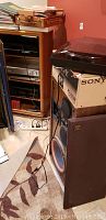 Cerwin Vega speaker visible with open front grill, wood grain finish, and speaker cone with orange surround showing.