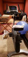 Front view of Life Fitness exercise bike showing digital console and handlebars with surrounding objects in room.