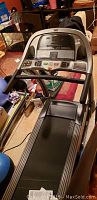 Front angled view of treadmill showing console, running belt and surrounding area