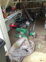Full view of the Billy Goat lawn vacuum with attached collection bag in a shed or garage setting with various tools in the background.
