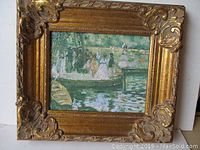 Frontal view of the framed oil painting showing the detailed gilt wood frame and the river scene with figures in boats.