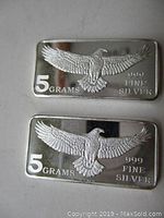 Front view of two rectangular silver ingots showing eagle with wings spread and purity markings '5 GRAMS' and '999 FINE SILVER'