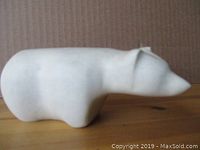 Side view of the white stone polar bear carving showing smooth texture and form.