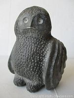 Full front view of Inuit black stone owl carving on white background