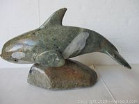 Front-side view of whale carving on base