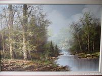 Full front view of the framed oil painting showing the wooded river landscape and artist signature.