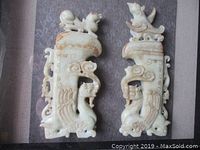 Close up of the two jade carvings side by side inside the shadow box, showing detailed carvings and texture.