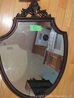 Full view of antique shield-shaped mirror revealing size and general condition