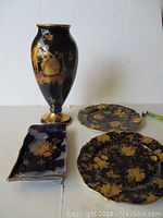 Full view of set showing Limoges vase, trinket tray, and two gold-edged decorative plates