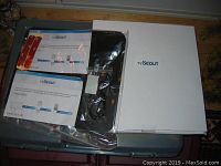 Two TV Scout Home Indoor antennas partially unpacked with cables and instruction sheets on a table with original packaging boxes.