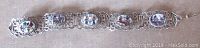 Full view of the vintage Egyptian silver tone link bracelet showing all five linked panels with different ancient Egyptian scenes and fold over clasp.