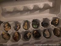 Photo showing all 13 tea figurines arranged in an egg carton style holder, each in an individual compartment, showing various animal and character shapes