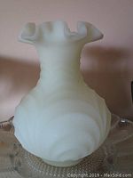 White opaque swirled glass vase with ruffled rim and spiral ribbed design on body