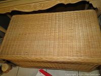 Top view of the flat woven wicker lid showing tightly woven pattern and good condition with no visible damage.