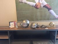Shelf view showing two battery clocks, two brass pig figurines, and two decorative shell items.